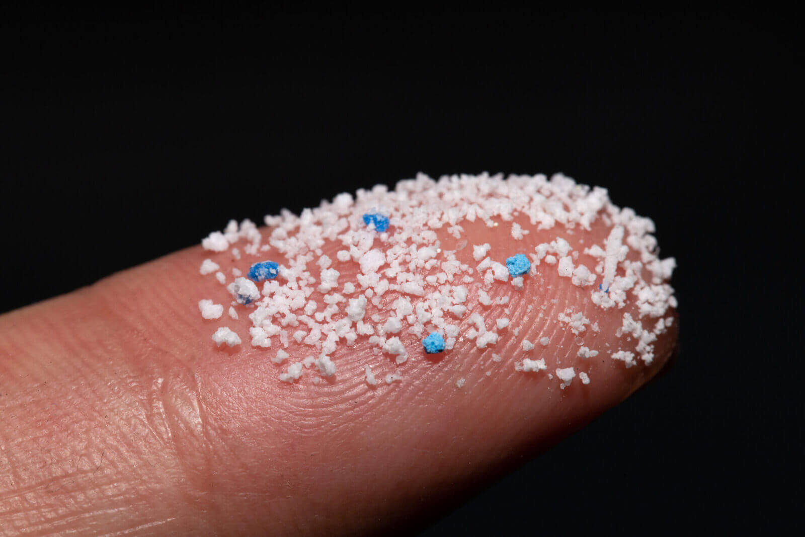 Microplastics on fingertip highlighting contamination concerns in Phoenix, AZ
