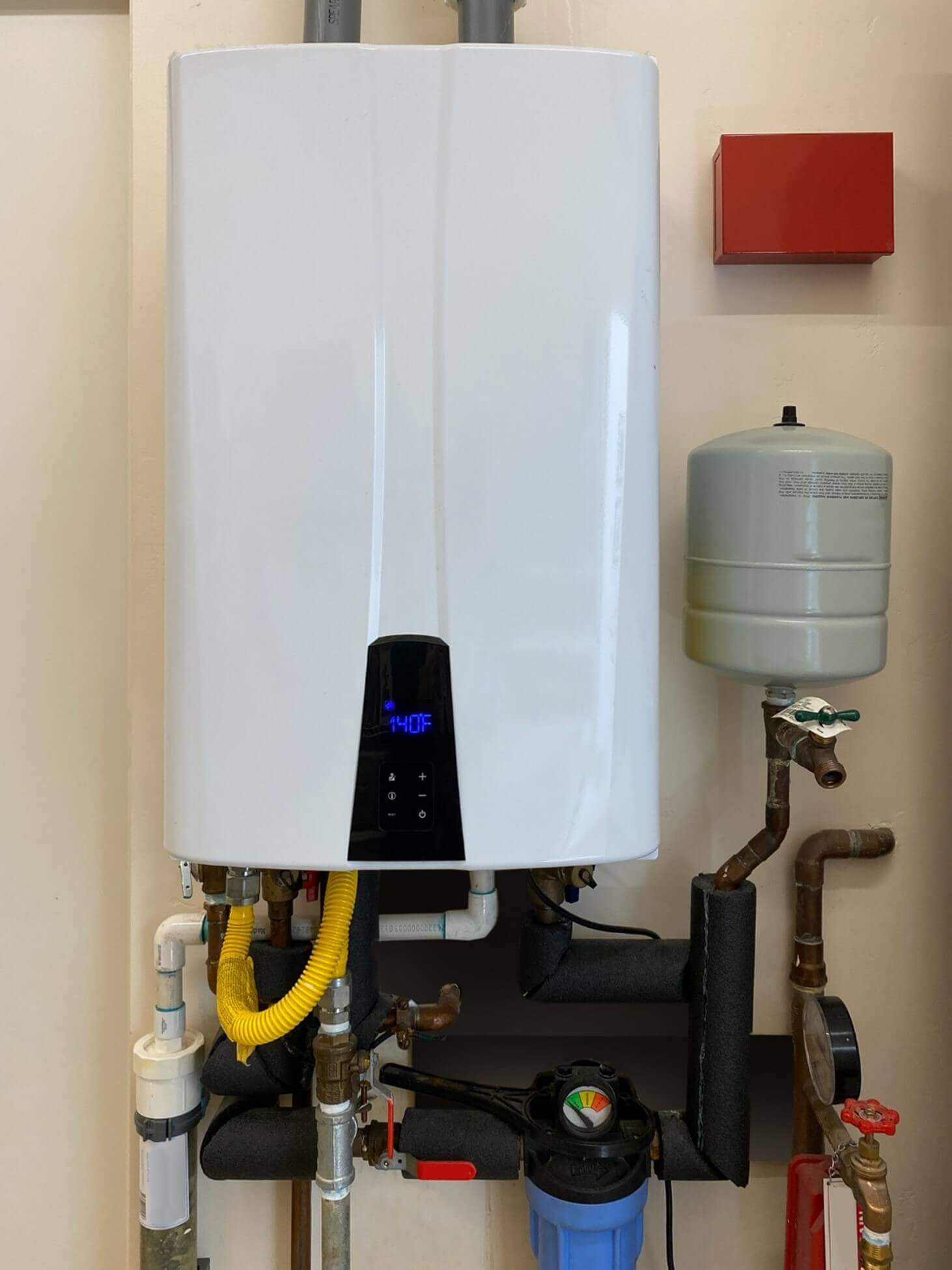 Installed tankless water heater system with pipes and filters in a home in Phoenix, AZ