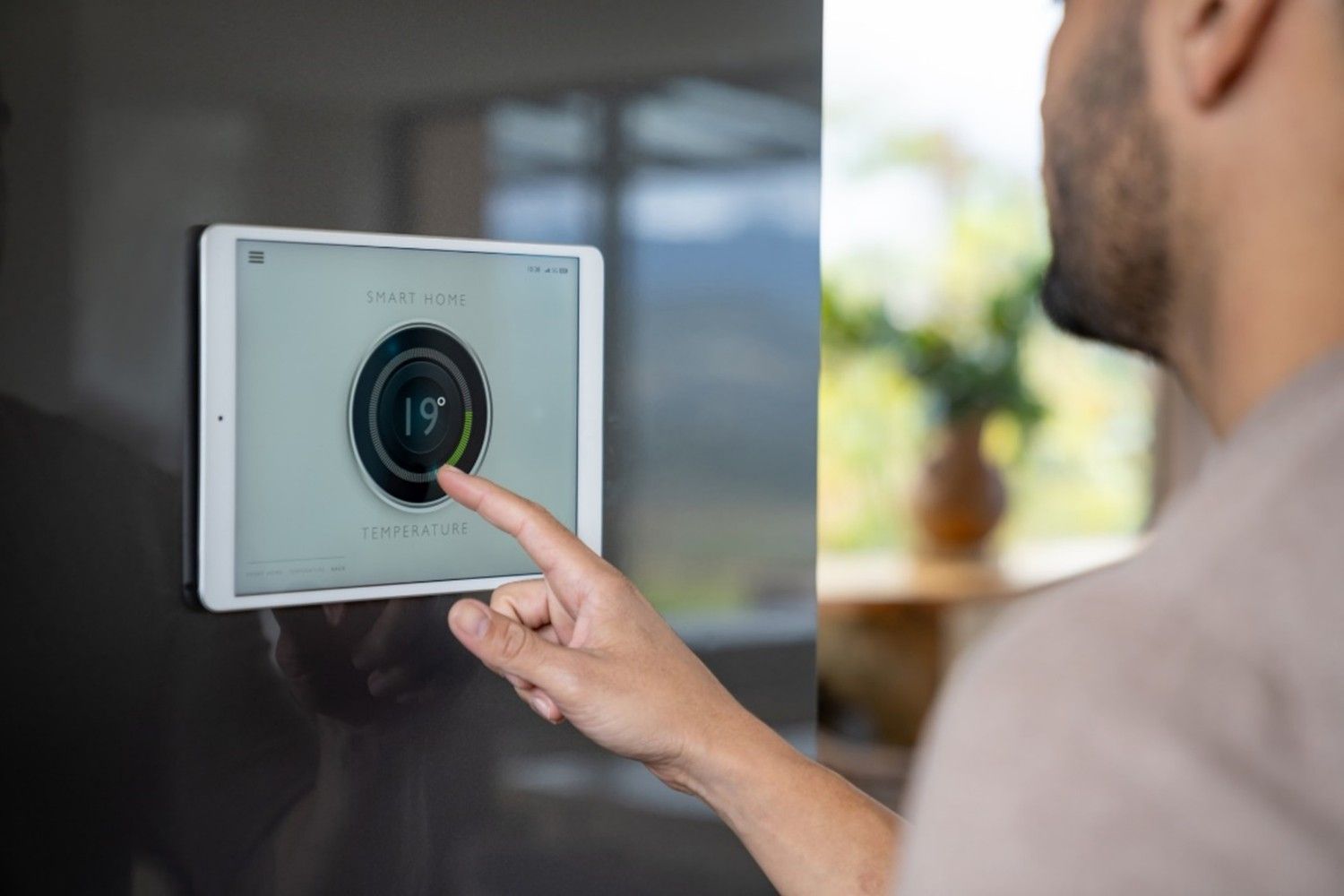 Person adjusting digital display for Smart Thermostat Integration on wall in Phoenix, AZ home